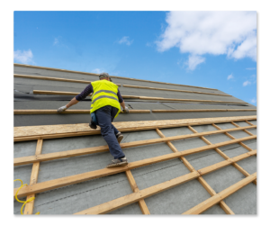 Roof installer standing on residential roof under construction